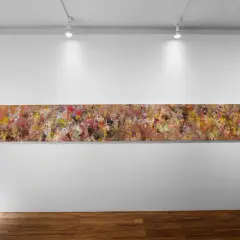 A long, abstract painting by Angela China artist, bursting with vibrant colors and textures, hangs on a white gallery wall.