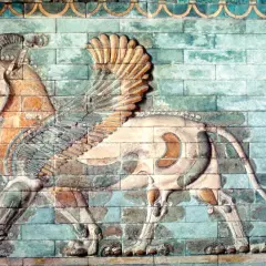 A winged lion with ram's horns, a magnificent example of ancient Iranian art, strides across a wall of glazed bricks.