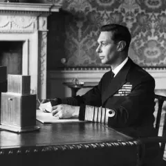 King George VI portrait: The monarch, in naval uniform, sits at a desk, holding a letter.