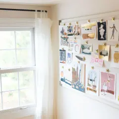 A mood board displays a collection of minimalist contemporary art prints, featuring cityscapes, figures, and whimsical illustrations, all clipped to a white board.