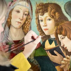 A modern artist meticulously restores a Renaissance painting, bringing to life the delicate details of angelic figures.