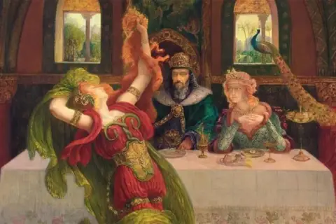 Salome dancing before Herod, her red dress and green veil swirling. Herod and his wife watch, a peacock nearby.