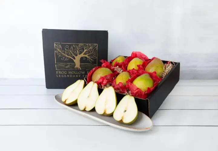 A box of pears, symbolizing longevity and abundance, sits beside a platter of halved pears.