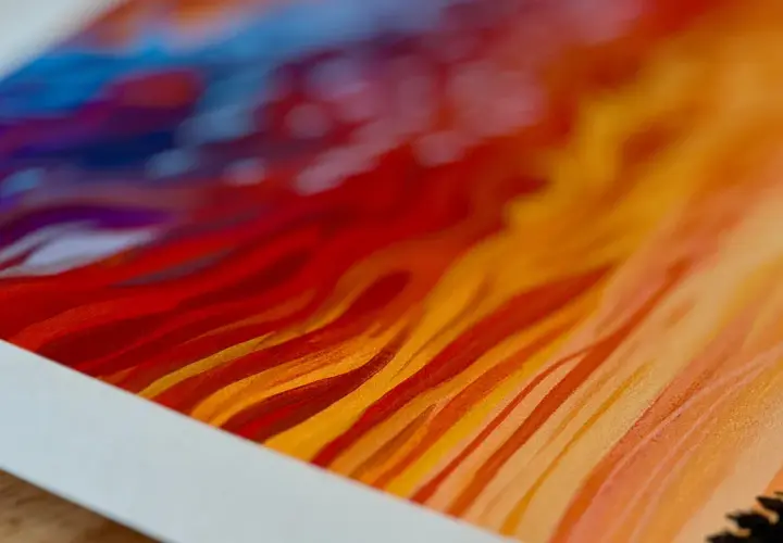 Close-up of a vibrant giclee print, showcasing fiery reds, oranges, and blues in abstract, flowing strokes.