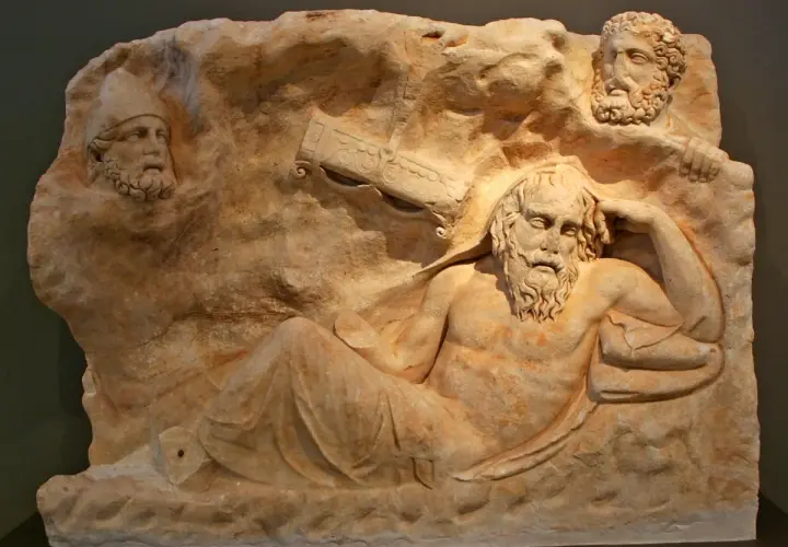 Relief sculpture depicts the wounded Philoctetes, abandoned and suffering, with two other figures observing him from above.