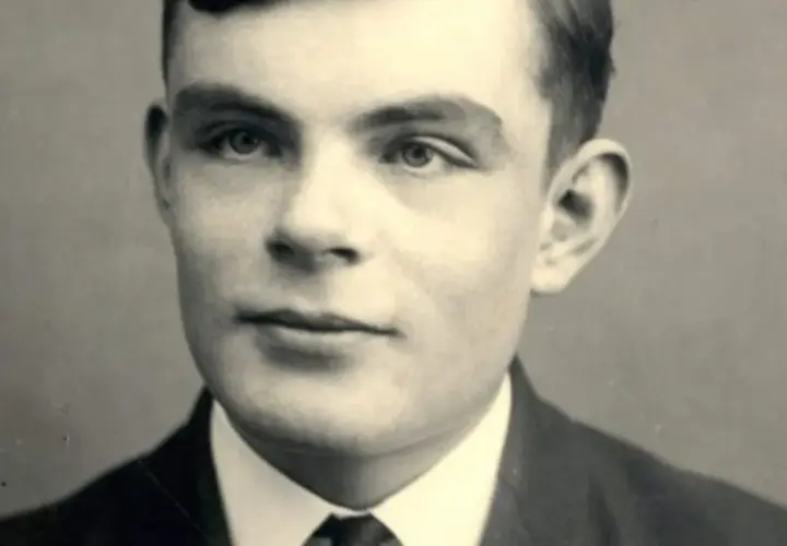 A young Alan Turing portrait, looking thoughtfully into the distance. This image captures the visionary mathematician who cracked Enigma.