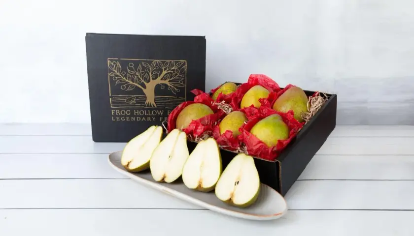 A box of pears, symbolizing longevity and abundance, sits beside a platter of halved pears.