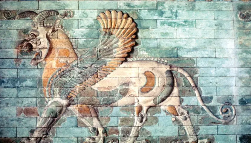 A winged lion with ram's horns, a magnificent example of ancient Iranian art, strides across a wall of glazed bricks.