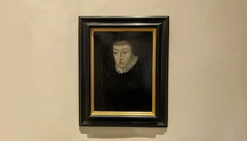 A dark portrait of Catherine de Medici, her gaze direct, framed by a ruffled collar and a dark headdress.