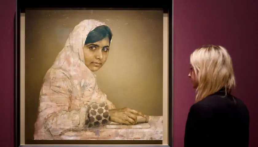 A striking **Malala Yousafzai portrait** shows her looking thoughtfully, her hands resting on a book. A woman observes the artwork.