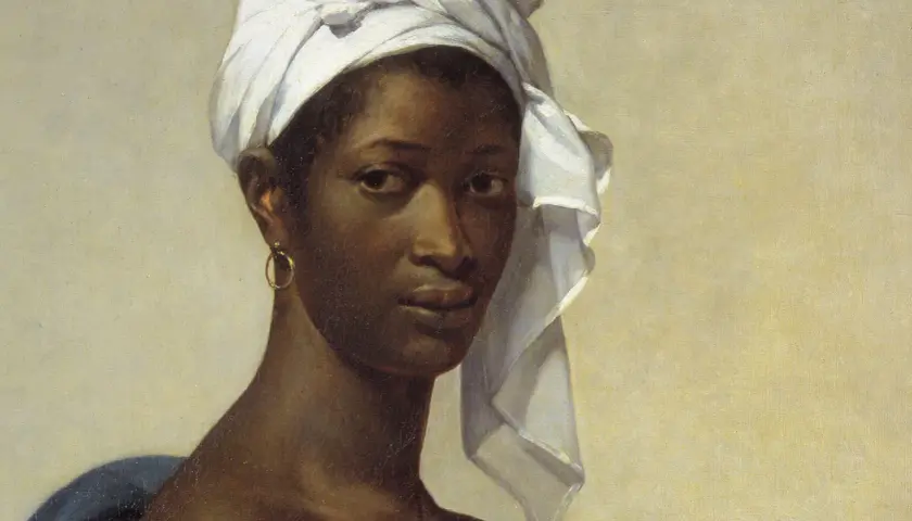 A striking portrait of Madeleine, her gaze direct, a white turban framing her face, and a gold hoop earring adorning her ear.