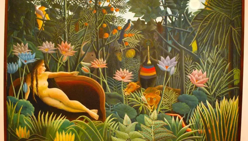 A woman reclines in a lush jungle, surrounded by exotic flowers and watchful lions. This is a classic example of Henri Rousseau's jungle paintings, filled with vibrant colors and a dreamlike atmosphere.