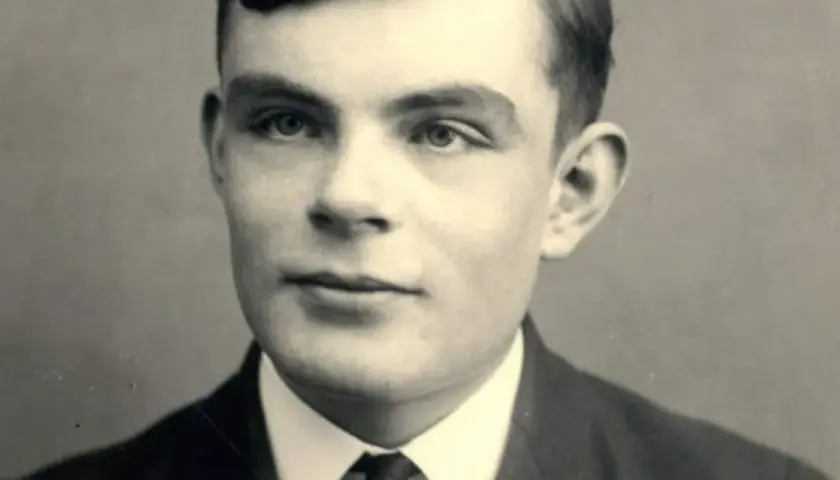 A young Alan Turing portrait, looking thoughtfully into the distance. This image captures the visionary mathematician who cracked Enigma.