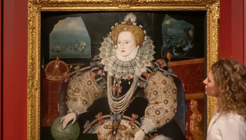 A woman gazes at a regal queen Elizabeth portrait, adorned in a jeweled gown and ruff, with a globe and crown nearby.