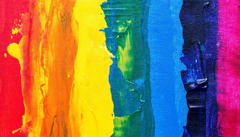Thick, textured paint strokes in red, orange, yellow, green, blue, and pink demonstrate what is color theory in art, showing how colors interact.