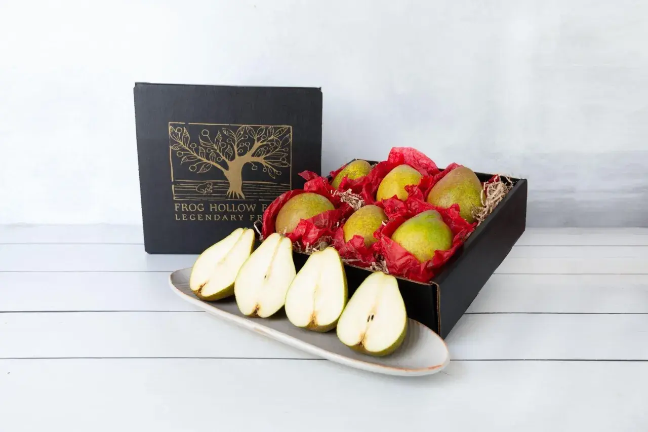 A box of pears, symbolizing longevity and abundance, sits beside a platter of halved pears.