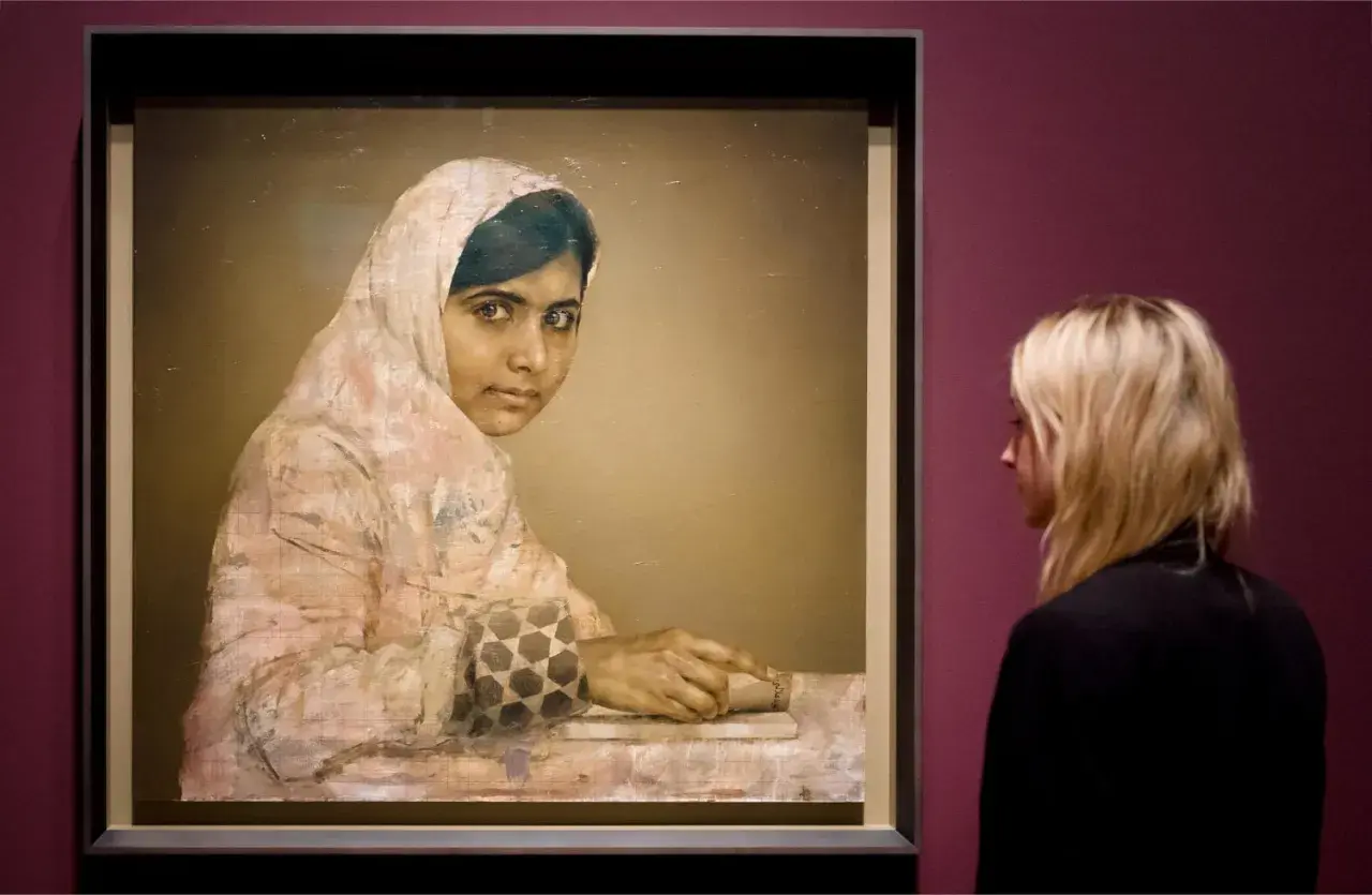 A striking **Malala Yousafzai portrait** shows her looking thoughtfully, her hands resting on a book. A woman observes the artwork.