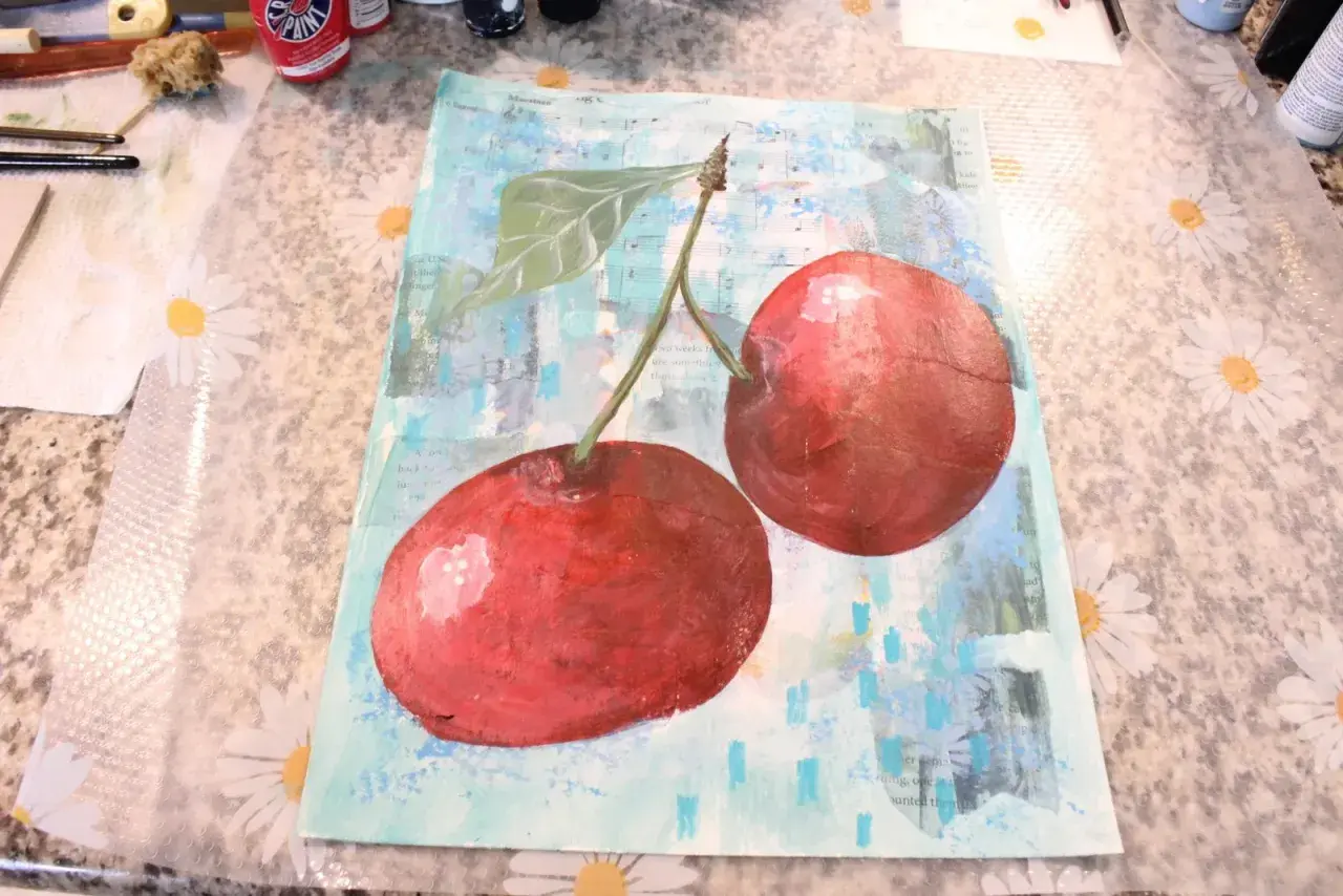 A vibrant collage and painting features two juicy cherries against a background of sheet music and abstract blue strokes.