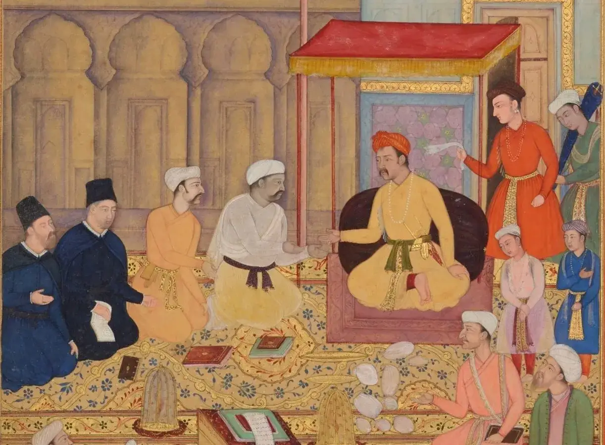 A vibrant scene from Mughal miniature paintings depicts a royal court. Men in ornate attire kneel and stand, engaged in conversation and presenting items.