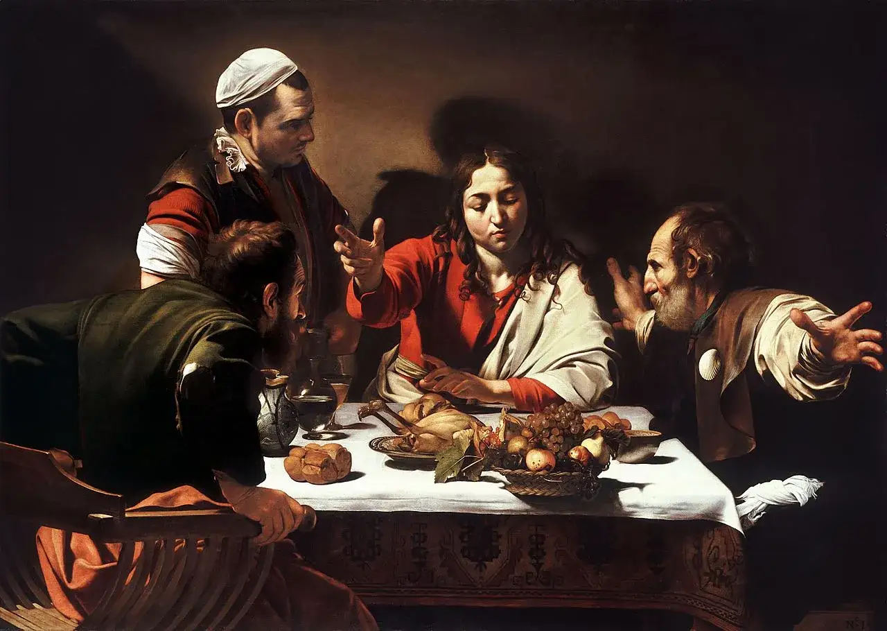 Caravaggio's Supper at Emmaus: Jesus, with a gesture of blessing, reveals himself to two disciples at a table laden with food.