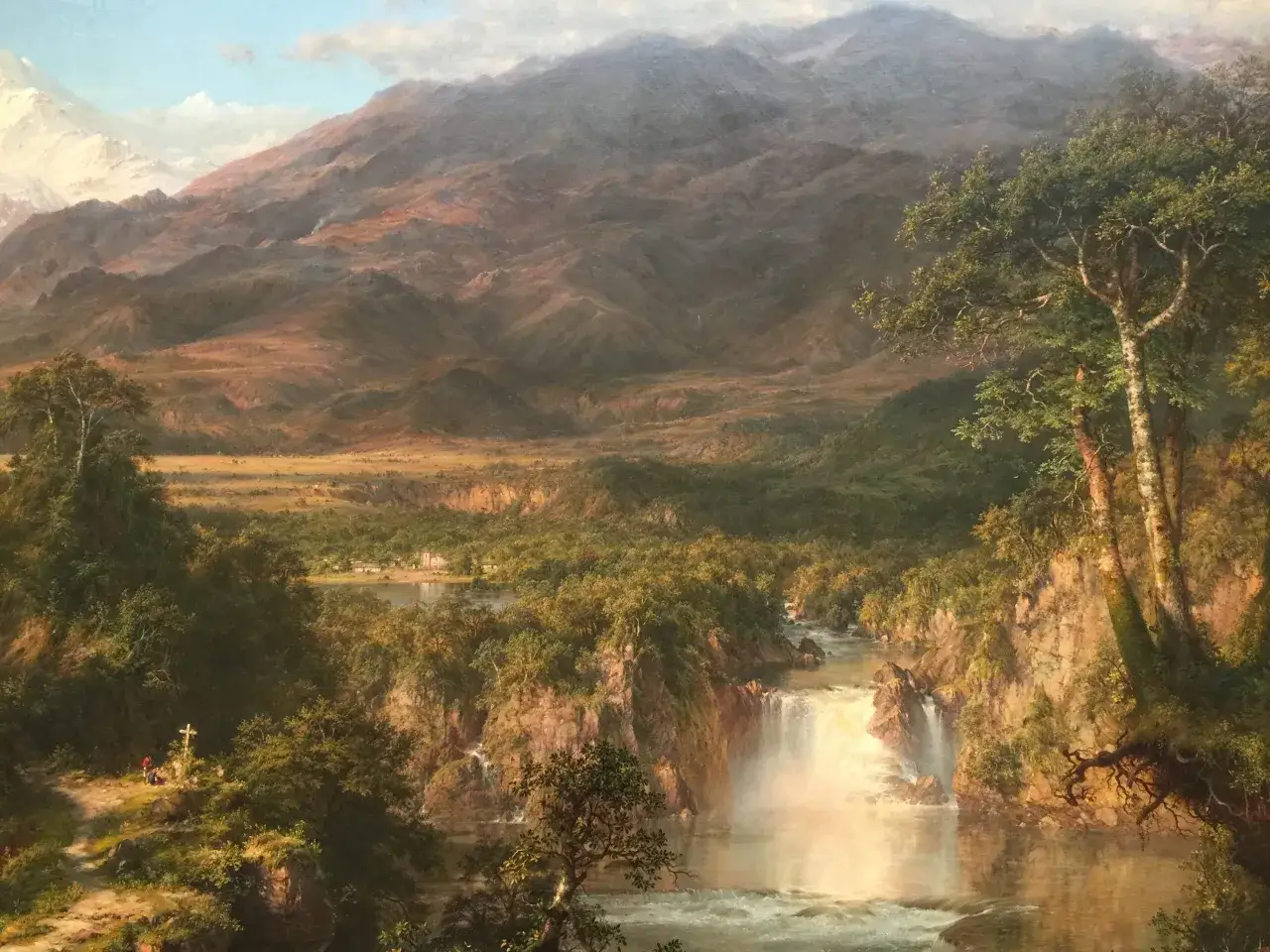 A majestic waterfall cascades through a lush valley, surrounded by rugged mountains. This scene captures the raw beauty of the heart of the Andes.